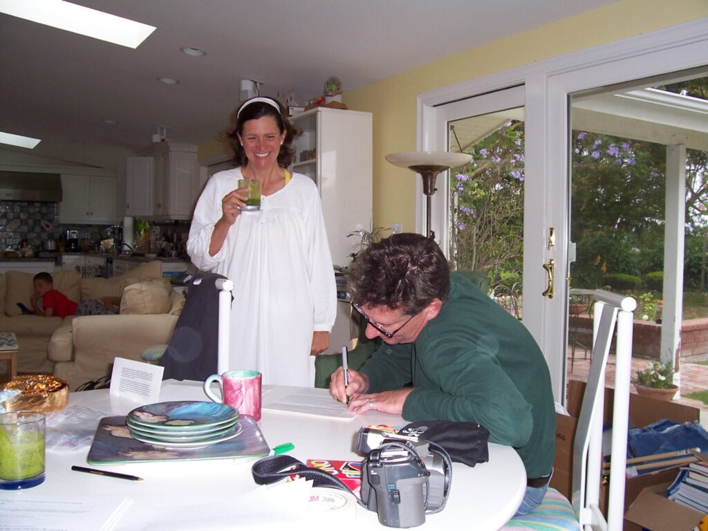 Dave Williams fills out his "Amazing Race" application while wife Yolanda Williams looks on.