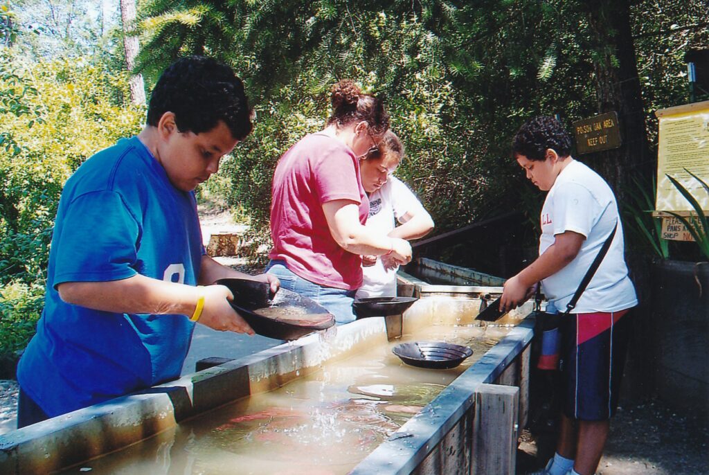 Visitors pan for gold in one of the wooden troughs ($2 an hour per pan) at Hangtown's Gold Bug Park.