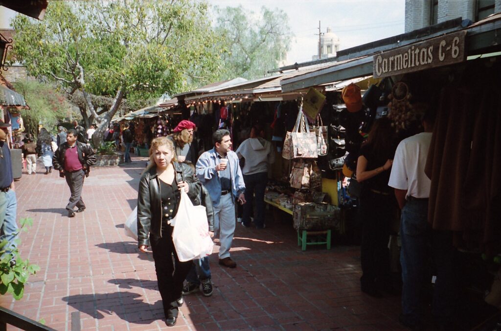Tightly packed stalls run down Olvera Street in old L.A., with shops and restaurants on its sides. 
